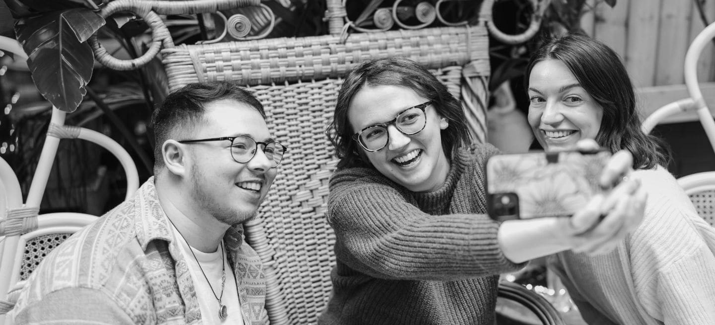 Compañeros de Awin tomándose una selfie con un iPhone