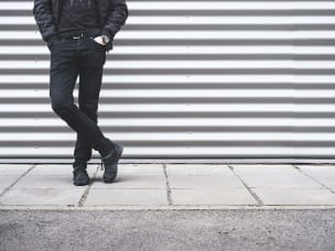 Foto di uomo senza volto in piedi su sfondo a righe