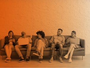 cinque ragazzi seduti su un divano con smartphone e pc