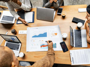 4 Menschen mit Laptops am Tisch