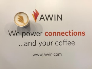 Tre membri dello staff Awin all'accoglienza dell'area lounge 