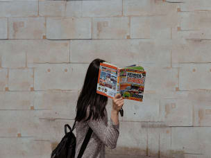 Ragazza che si nasconde dietro a un libro