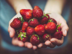 hand filled with strawberries