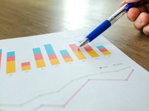 Graph shown on piece of paper, hand with pen