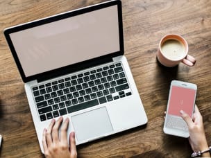 Laptop in una mano e telefono dall'altra