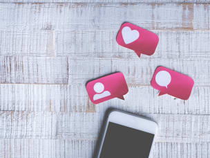 iPhone appoggiato su una scrivania con emoticon