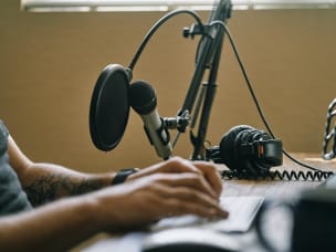 Man with microphone recording podcast in home studio