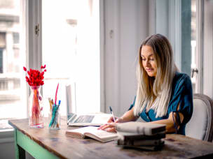 Ragazza che scrive sull'agenda alla scrivania