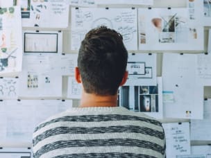 Man staring at brainstorming board for making decisions and thinking