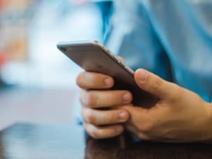 zwei Hände halten ein Handy