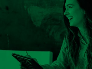 Ragazza sorridente che prende appunti