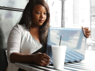 Girl in a coffee place working on her laptop