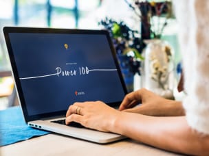 Person typing on laptop, looking at "Power 100" a year after its launch