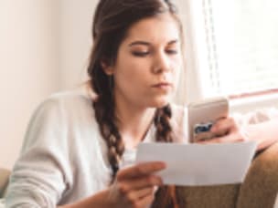 Women checking her marketing budget, amid staying ahead in cost-of-living crisis with Awin's retail hacks