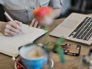 Person researching and taking notes about affiliate marketing and what it is