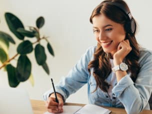 Person attending Awin's exclusive influencer marketing focused webinar, jotting down insightful information