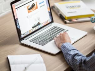 Person am Laptop am Erstellen mehrerer Affiliate-Tracking-Links mit Awins Link Builder API