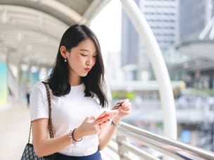 Person on phone, online shopping with rewards (GWP) through Awin's new partnership with BrandSwap 