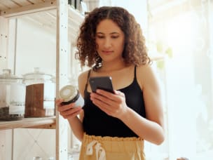 Person holding jar and phone in store