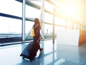 Person at the airport with their luggage for Awin presenting their "Top 10s – Travel Affiliates"