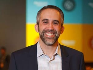 Awin & ShareASale President Adam Weiss in front of Awin's orange background