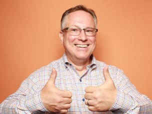 Scott Brinker smiling with an orange background