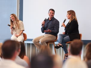 Three cheerful speakers, on stage, at ThinkTankUS