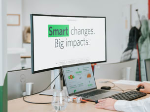 Employee on computer that shows "Smart changes. Big impacts." text for Awins new affiliate features