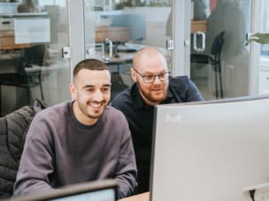 Zwei Mitarbeitende vor einem Computerbildschirm zur Aktualisierung des Tracking-Setups ist für Advertiser