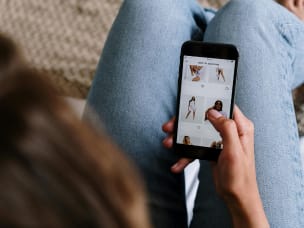 Person browsing clothing on smartphone