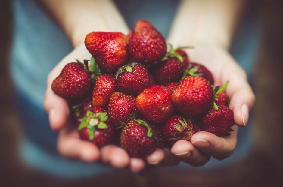 hand filled with strawberries