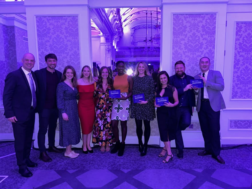 Awin MitarbeiterInnen posieren bei den Global Performance Marketing Awards 2022 mit den vier Preisen