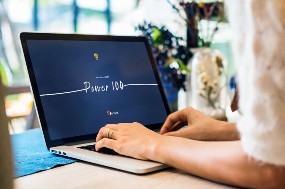 Person tippt auf einem Laptop und schaut sich ein Jahr nach dem Start die "Power 100" an