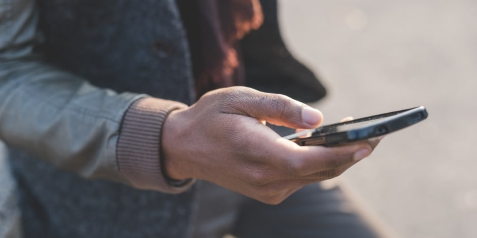 Handy in der Hand in einer Großstadt