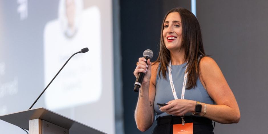 Awin speaker on stage holding a microphone at ThinkTank US 2024