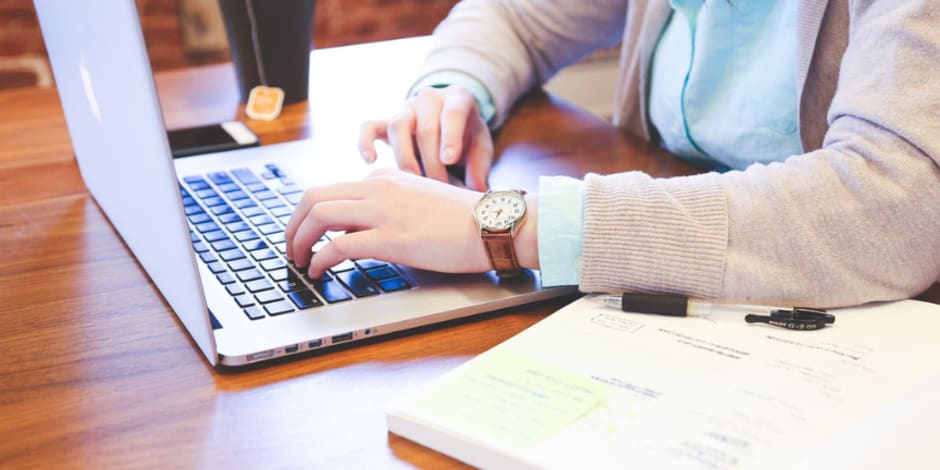 Person on their laptop, exploring Google’s attribution model, GA4, and how it impacts to measure affiliate activity