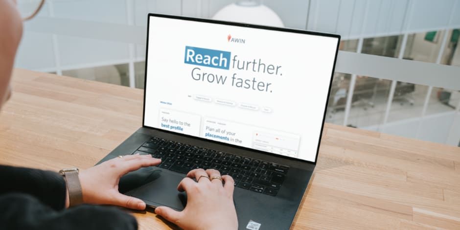 Laptop screen saying "Reach further. Grow faster." for Awin's new Winter 2024 releases