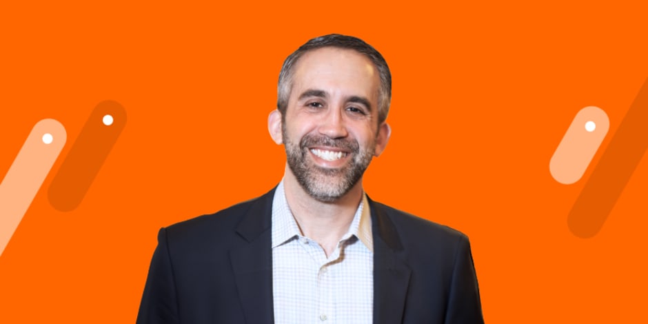 Awin & ShareASale President Adam Weiss in front of Awin's orange background