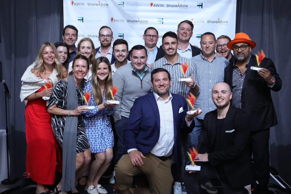 A group of seventeen people, seven of them holding awarded prizes, at the ThinkTank Network Awards.