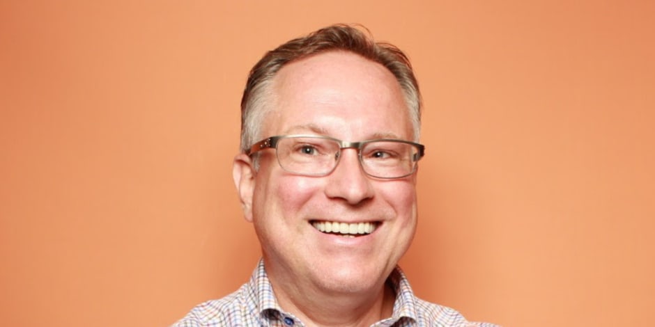 Scott Brinker smiling with an orange background