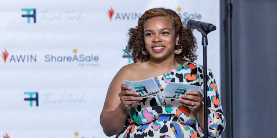 A person on stage making an announcement at the ThinkTank Network Awards in Chicago.
