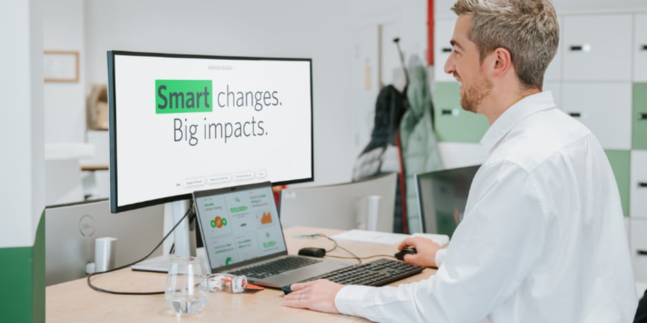 Employee on computer that shows "Smart changes. Big impacts." text for Awins new affiliate features
