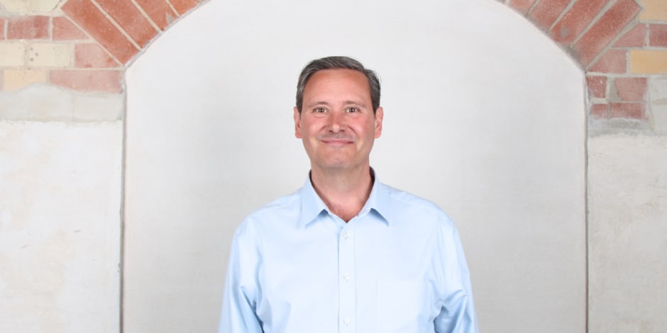 Gary Reck, standing in front of a wall, is the new Chief Product and Technology Officer at Awin