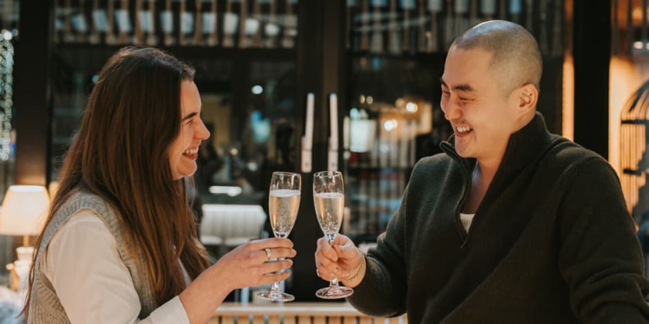 2 Awin employees have a toast in restaurant after winning 4 awards at the Performance Marketing Awards 2024