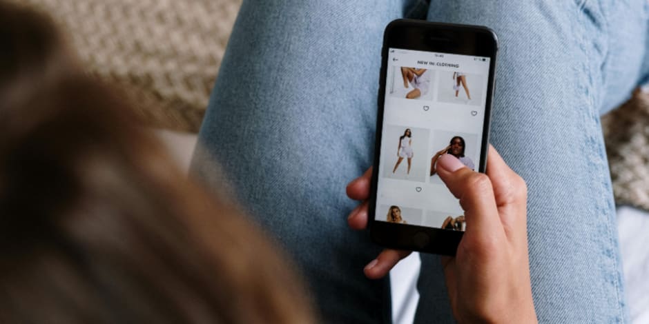 Person browsing clothing on smartphone