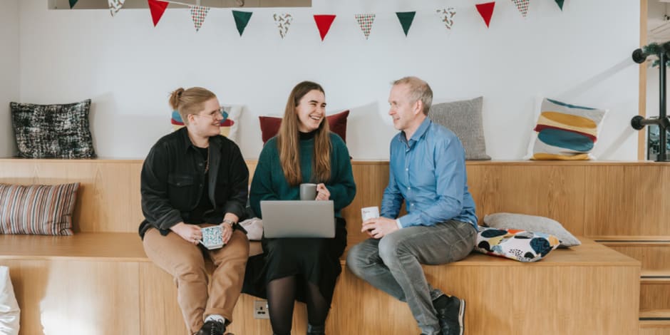 Three people sitting and talking in a casual office setting