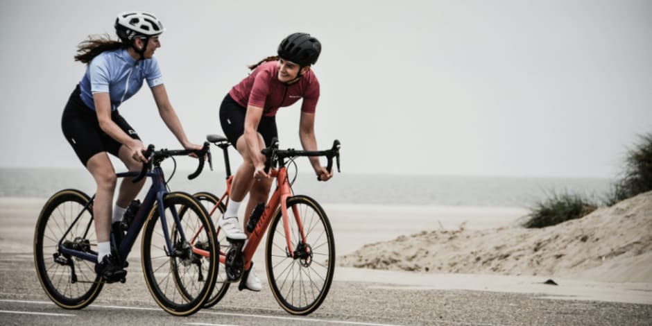 Two cyclists riding near beach
