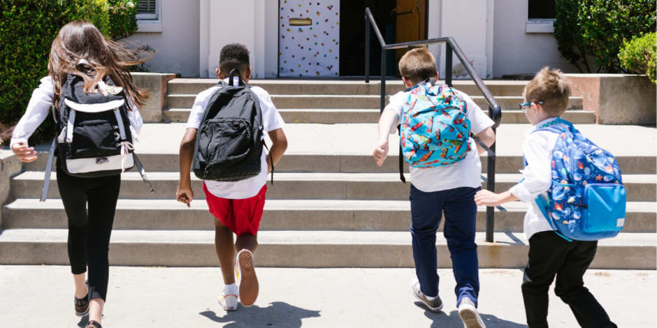 Children with backpacks entering a school building, representing education trends or youth-focused affiliate strategies.