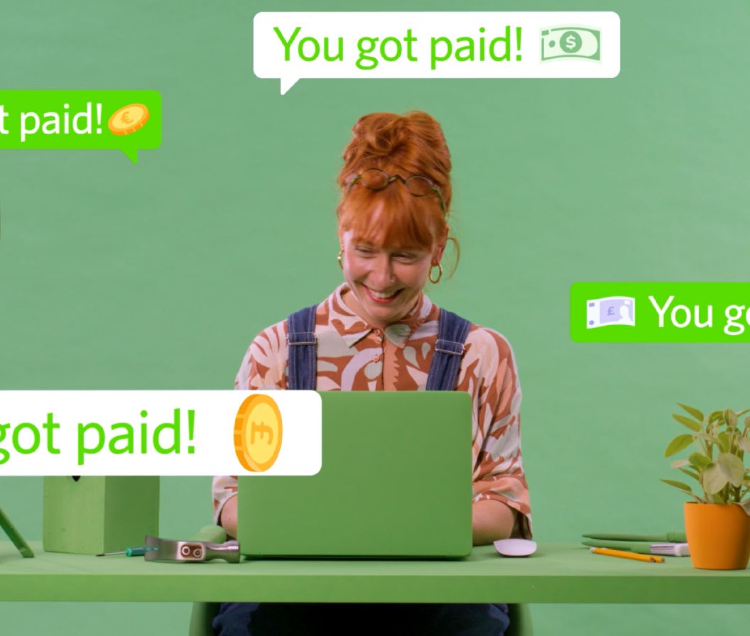 Green setting with a happy person working on a laptop 