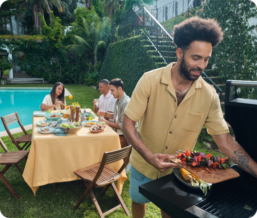 Group enjoying grilled food in a backyard setting.